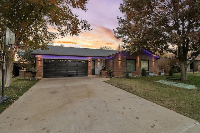 ranch-style home with a garage and a lawn