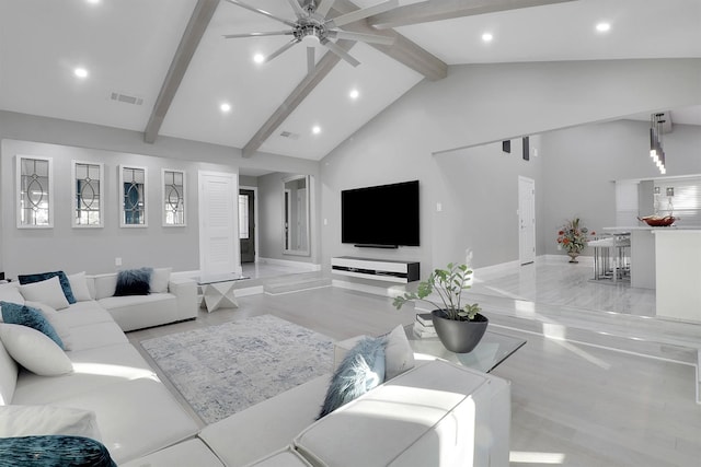 living room with ceiling fan, beam ceiling, light hardwood / wood-style floors, and high vaulted ceiling