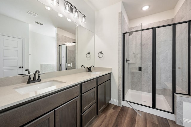 bathroom featuring hardwood / wood-style floors, vanity, and a shower with shower door