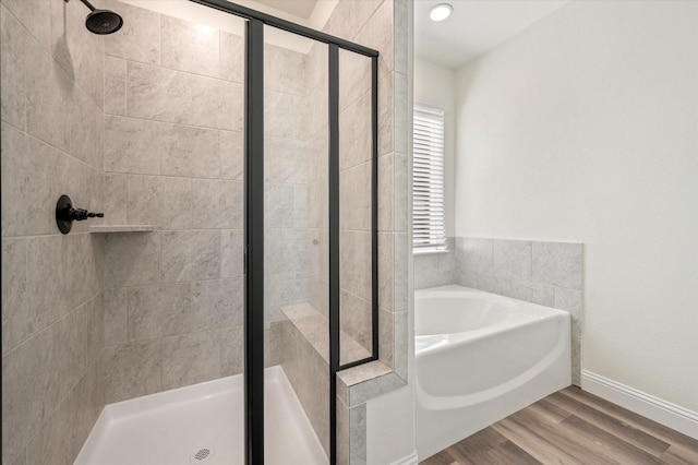 bathroom with hardwood / wood-style flooring and separate shower and tub