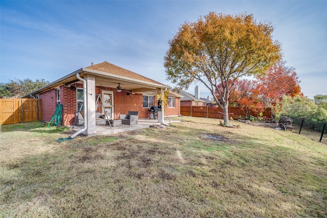 back of house featuring a patio, ceiling fan, and a lawn