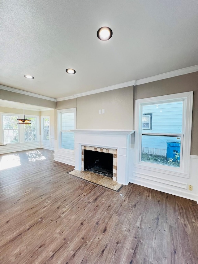 1601 Ficklin Ave, Corsicana, TX 75110 - unfurnished living room with a fireplace with flush hearth, wood finished floors, an inviting chandelier, and crown molding