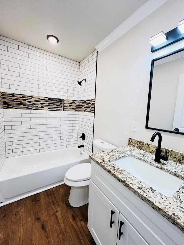 full bathroom featuring toilet, ornamental molding, vanity, tiled shower / bath combo, and hardwood / wood-style flooring