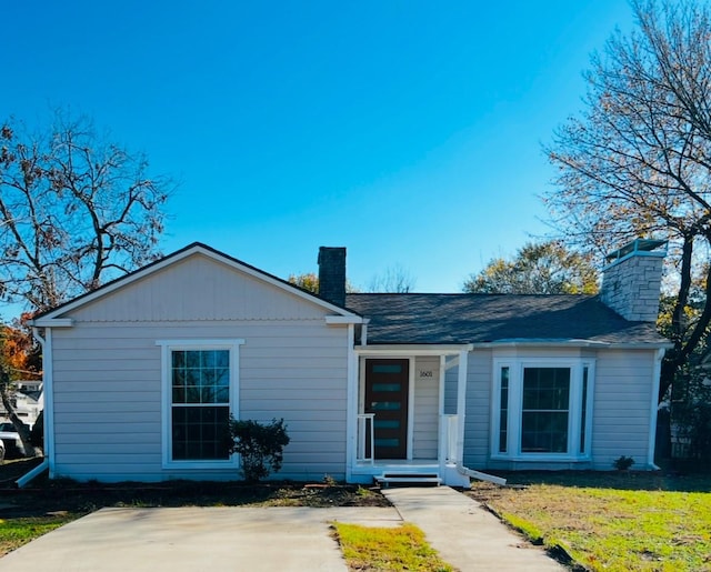 ranch-style house with a chimney and a front lawn