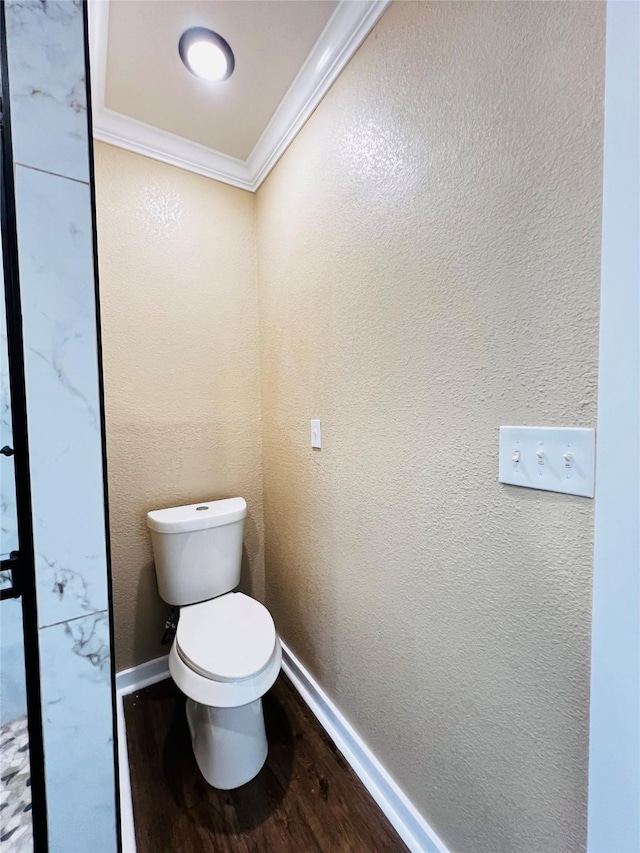 bathroom featuring ornamental molding, hardwood / wood-style floors, and toilet