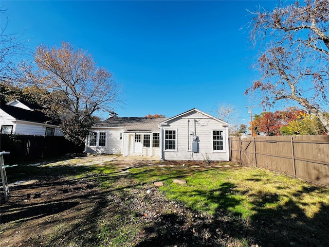 rear view of property featuring a lawn