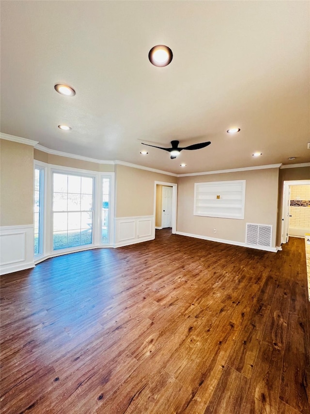 1601 Ficklin Ave, Corsicana, TX 75110 - unfurnished living room with crown molding, a decorative wall, wood finished floors, and visible vents