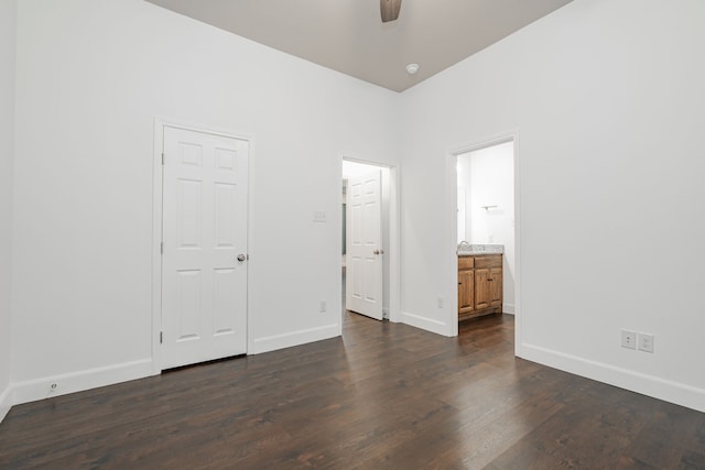 unfurnished bedroom with dark wood-type flooring and connected bathroom