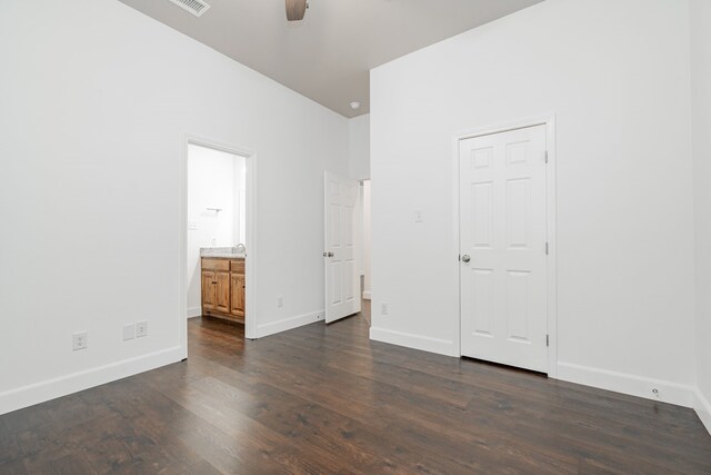 unfurnished bedroom featuring ceiling fan, connected bathroom, and dark hardwood / wood-style floors