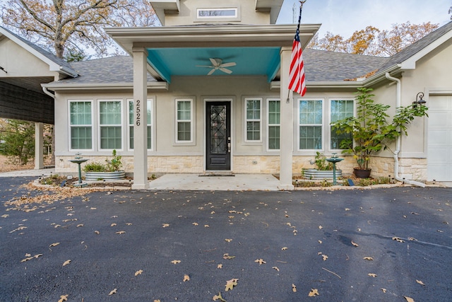 doorway to property with ceiling fan and a garage