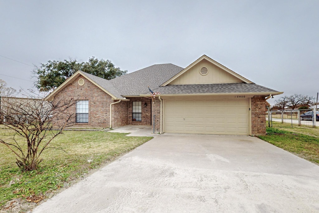 ranch-style house featuring a garage and a front yard