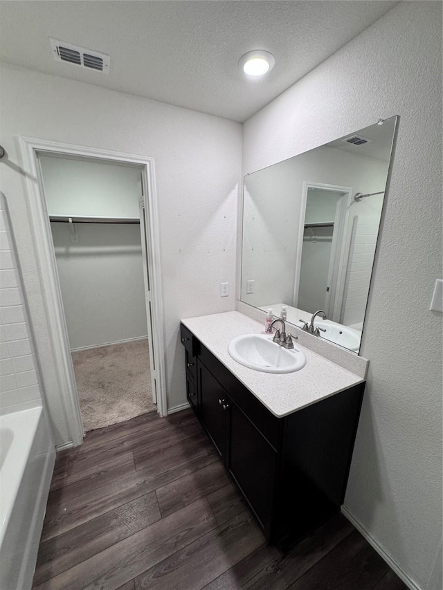 bathroom featuring vanity, tub / shower combination, hardwood / wood-style floors, and a textured ceiling