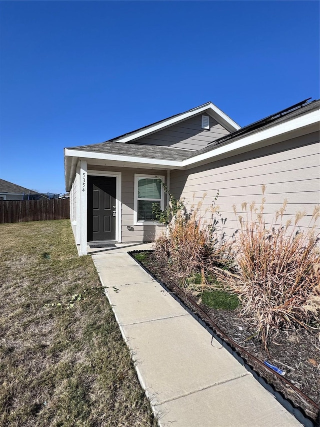 view of exterior entry with a yard