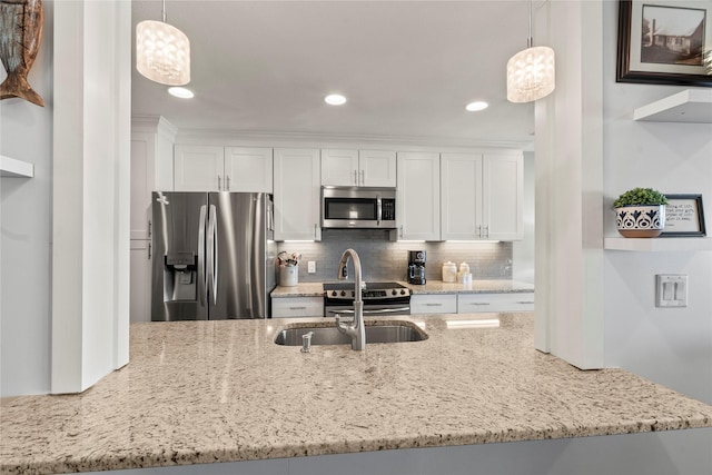 kitchen featuring pendant lighting, tasteful backsplash, stainless steel appliances, and white cabinets