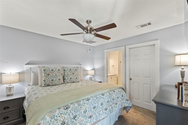 carpeted bedroom with ensuite bath and ceiling fan