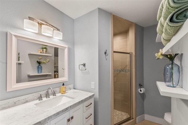 bathroom with vanity, toilet, and a shower with door