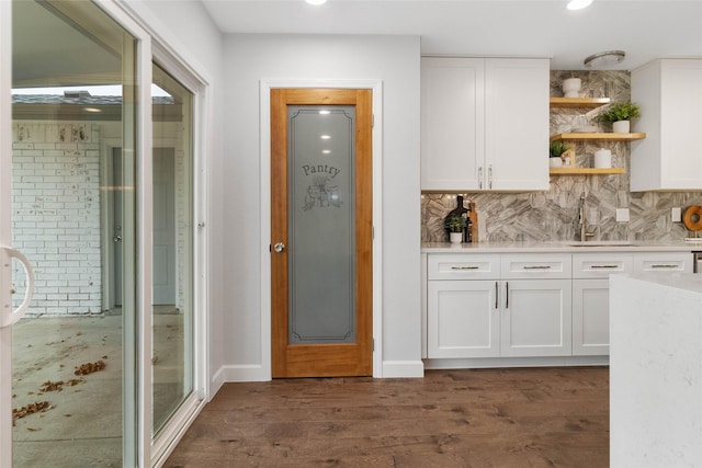 kitchen featuring white cabinets, dark hardwood / wood-style floors, decorative backsplash, and sink