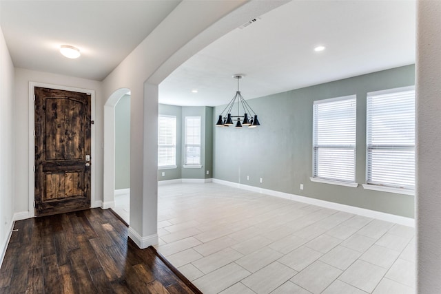 foyer entrance with a chandelier and light hardwood / wood-style floors