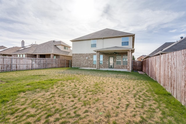 rear view of property featuring a yard and a patio area