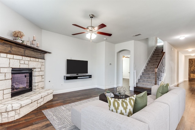 living room with ceiling fan, wood-type flooring, and a fireplace