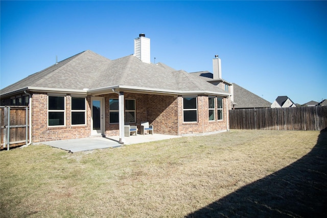 back of house with a lawn and a patio