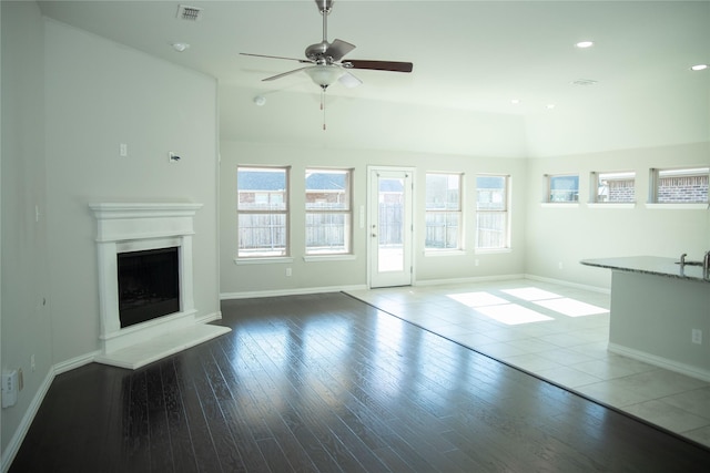 unfurnished living room with wood-type flooring and ceiling fan