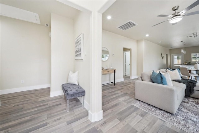 living room with ceiling fan and light hardwood / wood-style flooring