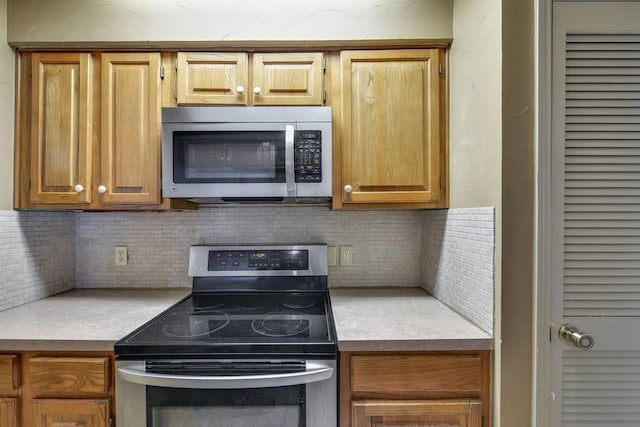 kitchen with stainless steel appliances and tasteful backsplash