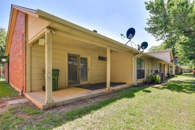 rear view of property featuring a yard and a patio