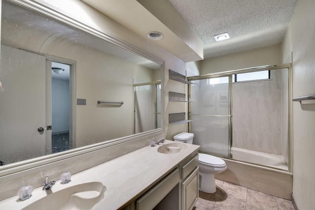 full bathroom featuring vanity, enclosed tub / shower combo, a textured ceiling, and toilet