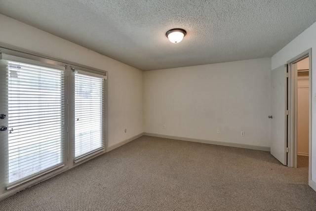 unfurnished room with light carpet and a textured ceiling