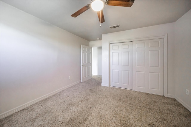 unfurnished bedroom featuring ceiling fan, a closet, and carpet