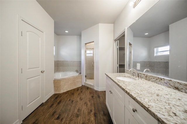 bathroom with hardwood / wood-style flooring, vanity, and independent shower and bath