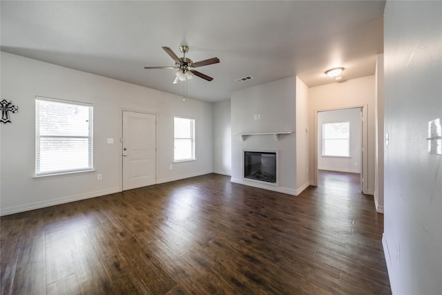 unfurnished living room featuring ceiling fan, plenty of natural light, and dark hardwood / wood-style floors