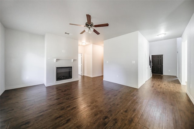 unfurnished living room with ceiling fan and dark wood-type flooring