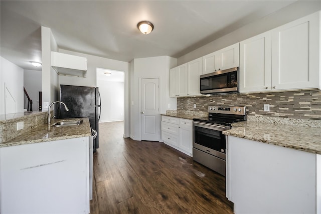 kitchen featuring dark hardwood / wood-style flooring, light stone counters, stainless steel appliances, sink, and white cabinetry