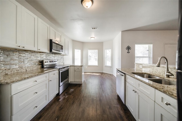 kitchen featuring white cabinetry, a healthy amount of sunlight, dark hardwood / wood-style floors, and appliances with stainless steel finishes