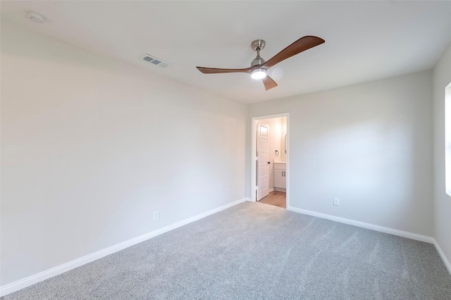 carpeted spare room featuring ceiling fan