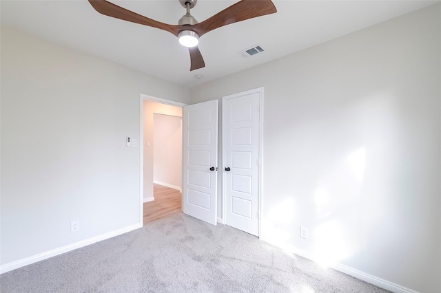 unfurnished bedroom with ceiling fan, a closet, and light carpet