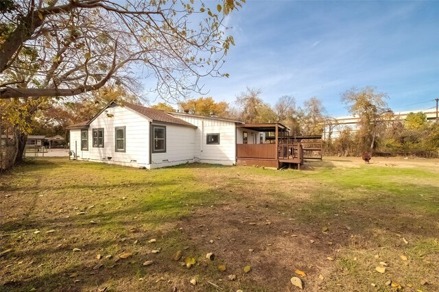 back of property with a yard and a wooden deck