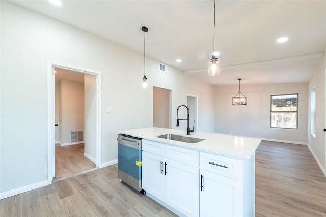 kitchen featuring white cabinetry, dishwasher, sink, decorative light fixtures, and a kitchen island with sink