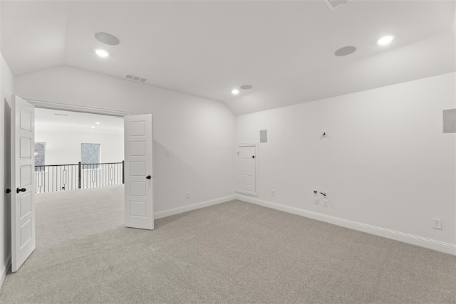 unfurnished room featuring light colored carpet and vaulted ceiling