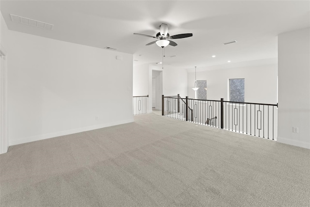 empty room featuring ceiling fan and light colored carpet