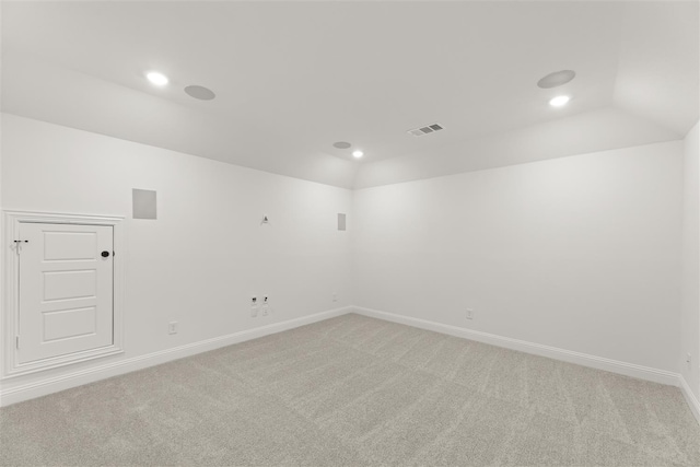 carpeted empty room featuring lofted ceiling