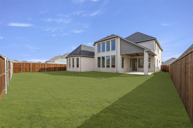 back of property featuring a yard, a patio, and ceiling fan