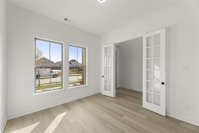 empty room featuring light hardwood / wood-style floors and french doors