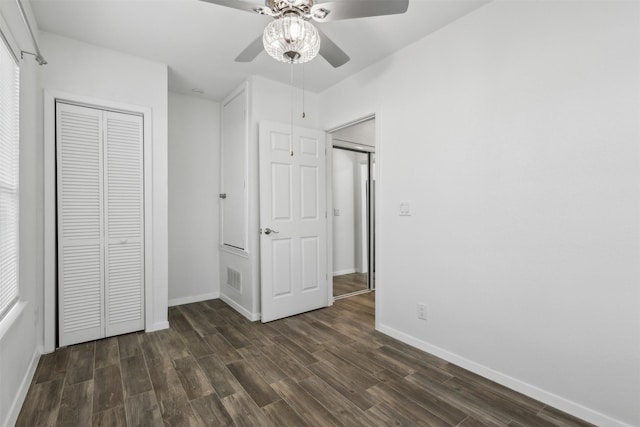 unfurnished bedroom featuring dark wood-type flooring, ceiling fan, and a closet