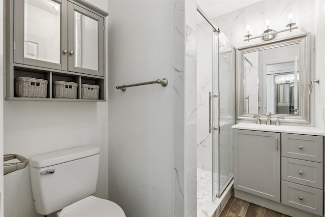 bathroom with vanity, hardwood / wood-style flooring, toilet, and walk in shower