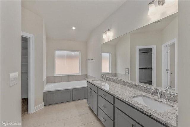 bathroom with a tub, tile patterned flooring, and vanity