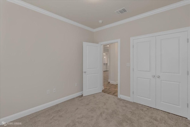 unfurnished bedroom featuring a closet, light colored carpet, and ornamental molding